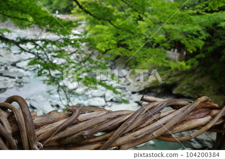 A part of the handrail of Iya Kazura Bridge and the Iya River flowing below A part of the handrail of Iya Kazura Bridge and the Iya River flowing below 104200384