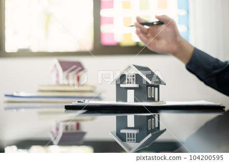 Agents working in real estate investment and home insurance signing contracts in accordance with the home buying insurance agreements approving purchases for clients 104200595