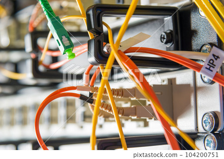 detail of server rack with fiber optic cables attached to front panel switch ports detail of server rack with fiber optic cables attached to front panel switch ports 104200751