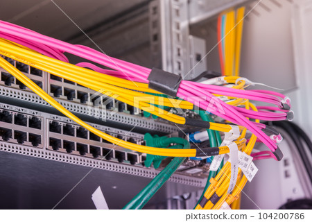 fiber optic cables connected to optic ports, network cables connected to ethernet ports 104200786