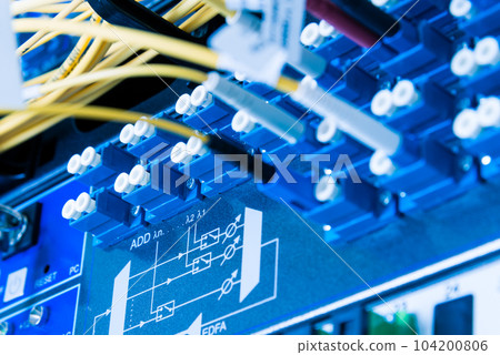 fiber optic cables plugged in network switch panel inside data center 104200806