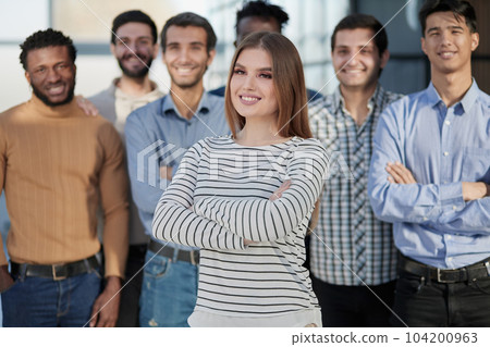 Smiling businesswoman looking at camera together with colleagues 104200963