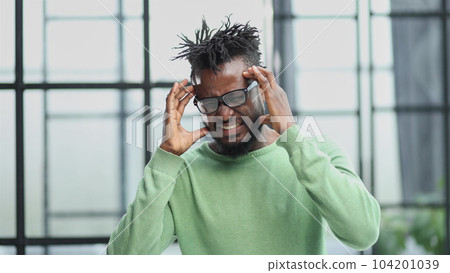african american man in a green shirt holding his hands behind his head 104201039