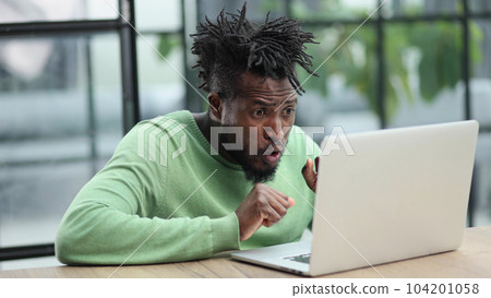 Young african american business man sitting in loft office or cafe, working on new online IT startup project, using laptop 104201058
