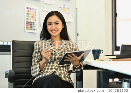 Attractive asian woman startup founder in smart trendy suit using digital tablet, working at creative office 104201300