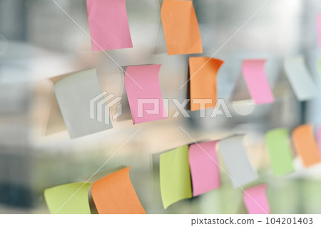 Closeup of colorful blank sticky notes, reminder paper note on glass wall in modern office 104201403
