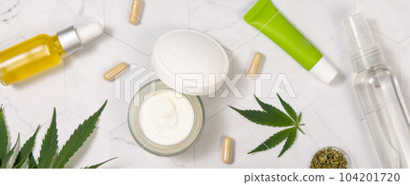 Cosmetic bottles, jars and tubes with blank label near green cannabis leaves. Mockup Cosmetic bottles, jars and tubes with blank label near green cannabis leaves. Mockup 104201720