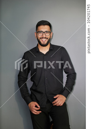 Young handsome business man dressed in casual denim shirt with smartwatch on wrist 104201745