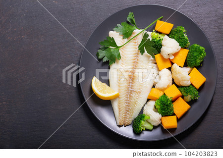 plate of fried cod fish fillet with vegetables, top view plate of fried cod fish fillet with vegetables, top view 104203823
