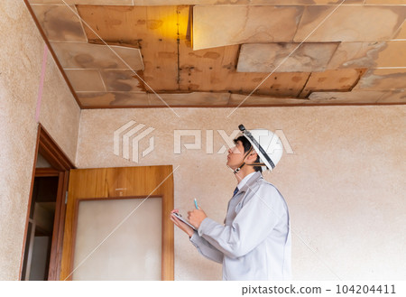 Businessmen investigating the leaked ceiling before housing renovation Businessmen investigating the leaked ceiling before housing renovation 104204411