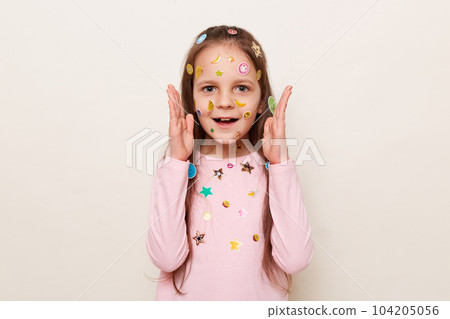 Portrait of amazed astonished little brown haired little girl covered with stickers posing isolated over white background showing big size with hands, looking at camera with big eyes. Portrait of amazed astonished little brown haired little girl covered with stickers posing isolated over white background showing big size with hands, looking at camera with big eyes. 104205056