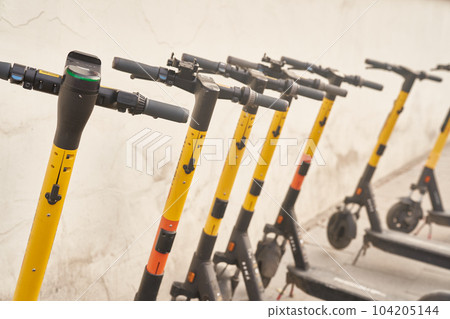 Several electric scooters. Electric scooters in the city. Vehicle for rent. The concept of modern urban transport and technology. High quality photo 104205144
