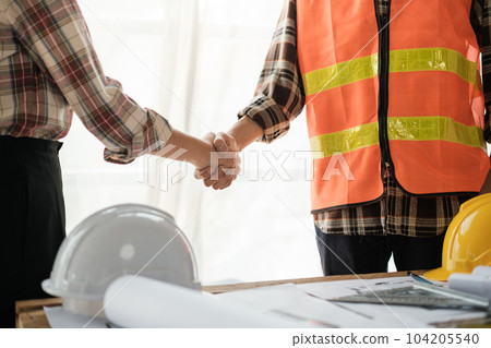 Close-up image of an engineer shaking hands with his coworker during the meeting. teamwork, building trust, unity 104205540