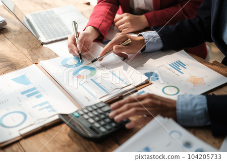 Team of two asian male and female business people working together discussing new financial graph data on office table with laptop and digital tablet. 104205733