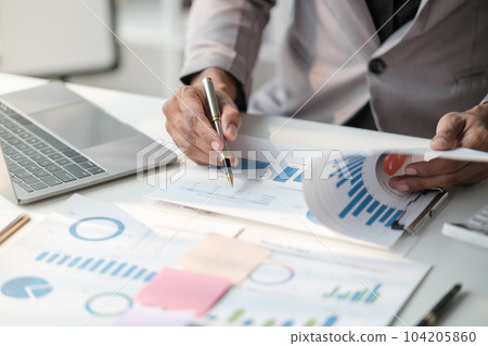 Close up young man with calculator counting making notes at home, hand is writing in a notebook. Savings finances concept 104205860