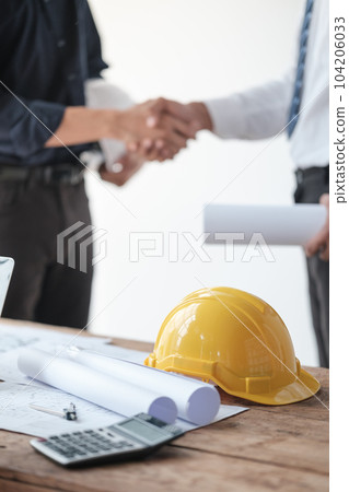 Close-up image of an engineer shaking hands with his coworker during the meeting. teamwork, building trust, unity 104206033