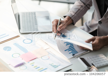 Close up young man with calculator counting making notes at home, hand is writing in a notebook. Savings finances concept 104206057