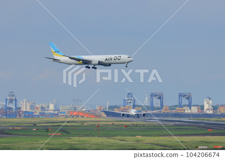 A passenger plane landing with the city of Tokyo in the background A passenger plane landing at Haneda Airport 104206674