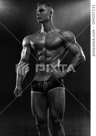 Bodybuilder showing off his perfect low fat body without clothes in studio Bodybuilder showing off his perfect low fat body without clothes in studio 104207131