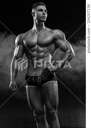 Bodybuilder showing off his perfect low fat body without clothes in studio Bodybuilder showing off his perfect low fat body without clothes in studio 104207136