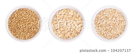 Oat grains, rolled oats and oatmeal, in white bowls. Husked common oat, Avena sativa, a cereal grain. Dehusked steamed oat groats, rolled into flat flakes, toasted, used whole or as steel-cut flakes. Oat grains, rolled oats and oatmeal, in white bowls. Husked common oat, Avena sativa, a cereal grain. Dehusked steamed oat groats, rolled into flat flakes, toasted, used whole or as steel-cut flakes. 104207137