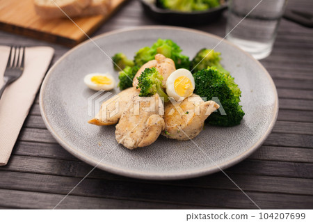 healthy appetizer of chicken pieces with broccoli and quail eggs in bowl for healthy lunch 104207699