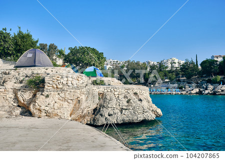 Tents on a cliff in sea lagoon Tents on a cliff in sea lagoon 104207865
