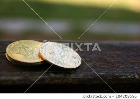 Bitcoin gold coin on wooden table with natural background, Bitcoin coin business concept. Bitcoin cryptocurrency. Bitcoin coin electronic money model. Bitcoin gold coin on wooden table with natural background, Bitcoin coin business concept. Bitcoin cryptocurrency. Bitcoin coin electronic money model. 104209556