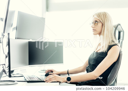 Female financial assets manager, trading online, watching charts and data analyses on multiple computer screens. Modern corporate business woman concept. Female financial assets manager, trading online, watching charts and data analyses on multiple computer screens. Modern corporate business woman concept. 104209946