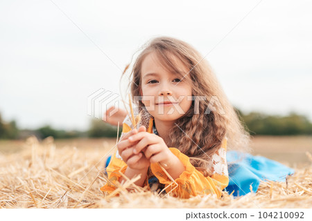 Ukraine's Independence Flag Day. Girl in traditional embroidery with flag of Ukraine in field. Constitution day. 24 August. Patriotic holiday. 104210092