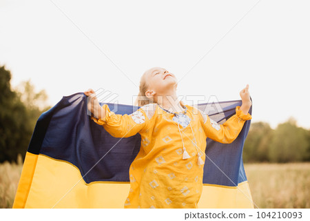 Ukraines Independence Flag Day. Constitution day. Ukrainian child girl in embroidered shirt vyshyvanka with yellow and blue flag of Ukraine in field. flag symbols of Ukraine. Kyiv, Kiev day 104210093