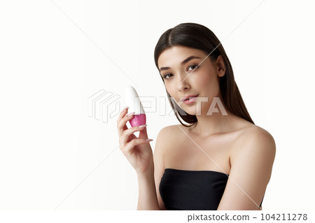 Portrait of beautiful young woman with smooth, clear skin, long hair posing with deodorant against white studio background 104211278