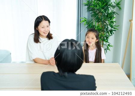 Conversation scene of a woman in a suit with a parent and child 104212493