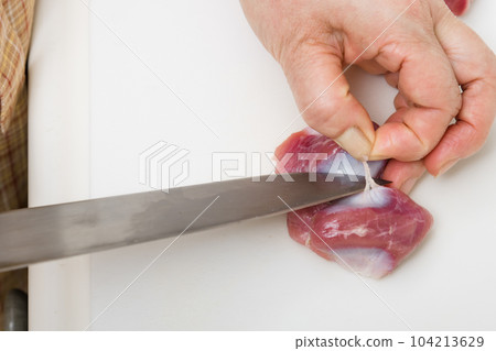 [Housewife preparing yakitori gizzards with a knife] 104213629