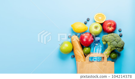 Shopping paper bag full of healthy food on blue 104214378