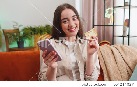 Young woman using credit bank card and smartphone, transferring money purchases online shopping Young woman using credit bank card and smartphone, transferring money purchases online shopping 104214827