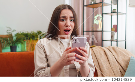 Sad young woman use smartphone surprised by bad news, fortune loss, fail, lottery results, deadline 104214829