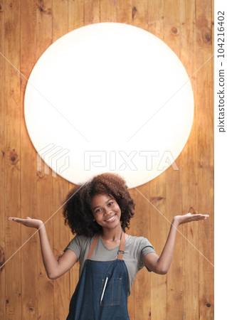 Successful african woman in apron standing coffee shop door. Happy small business owner holding tablet and working. Smiling portrait of SME entrepreneur seller business standing with copy space. 104216402