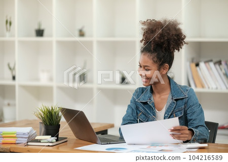 Smart African women working in beautiful office, working on Laptop, use the phone, talking on the cellphone. Smart African women working in beautiful office, working on Laptop, use the phone, talking on the cellphone. 104216589