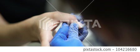 Manicurist specialist in gloves doing hardware manicure to client using special equipment Manicurist specialist in gloves doing hardware manicure to client using special equipment 104216680
