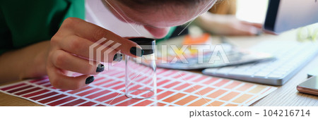 Graphic designer looking at colors samples through loupe Graphic designer looking at colors samples through loupe 104216714