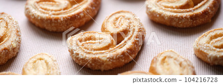Tasty sweet pastry cookies with sugar sprinkle on pink backdrop Tasty sweet pastry cookies with sugar sprinkle on pink backdrop 104216728