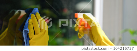 Female hands cleaning window outside using detergent spray and rag Female hands cleaning window outside using detergent spray and rag 104216737