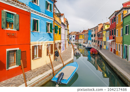 The Burano island near Venice, a canal with colorful houses. The Burano island near Venice, a canal with colorful houses. 104217486