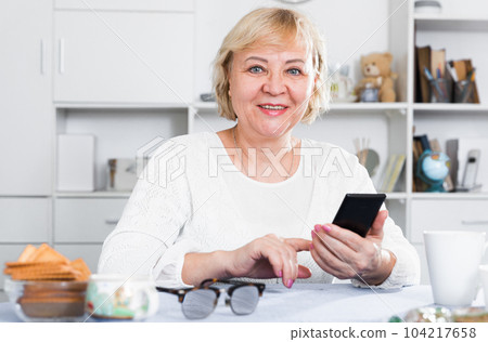 Mature woman with smartphone Mature woman with smartphone 104217658