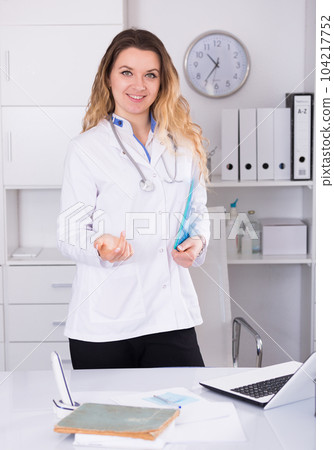 Medical worker in medical center standing near the table Medical worker in medical center standing near the table 104217752