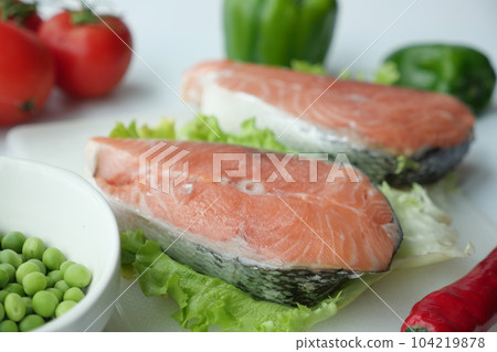 Raw, fresh salmon steak and vegetables on white Raw, fresh salmon steak and vegetables on white 104219878