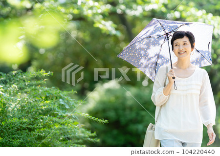 A middle-aged woman with a parasol A middle-aged woman with a parasol 104220440