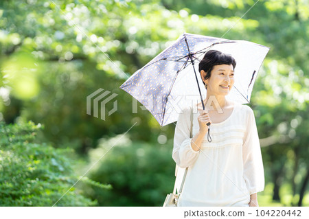 一個打著陽傘的中年婦女 104220442