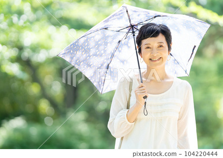 一個打著陽傘的中年婦女 104220444
